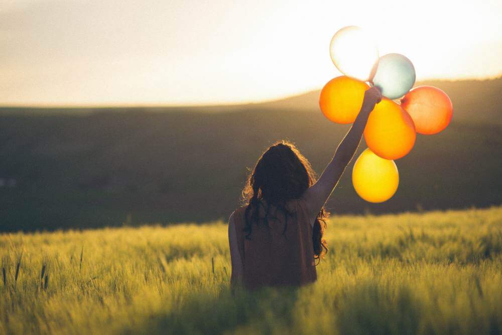 Happy Girl holding balloon | Know What Makes Us Happy with Happiness 2.0